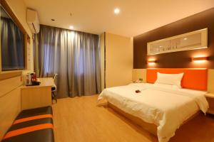 a hotel room with a bed and a television at 7Days Premium Guang'an Chaoyang Avenue Branch in Guang'an