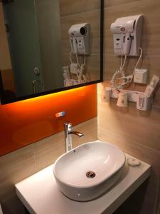 重慶的住宿－7天优品重庆江北国际机场店，浴室设有白色水槽和镜子