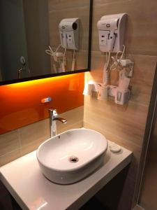 a bathroom with a white sink and a mirror at 7 Days Premium Chongqing Jiangbei International Airport Branch in Chongqing