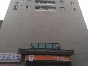 Un palazzo alto con un cartello davanti di 7Days Premium Xi'an Railway Station Central Plaza Airport Bus Branch a Xi'an