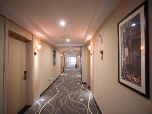a corridor of a hotel hallway with a painting on the floor at 7Days Premium Chongqing Baishiyi Hot Spring Capital Branch in Chongqing