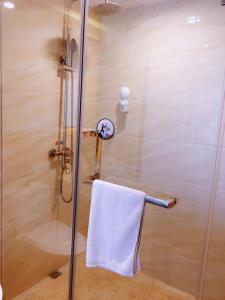 um chuveiro com uma toalha branca num toalheiro em 7Days Premium Chongqing Liangjiang New District Yufu Industrial Park Yuzui Branch em Chongqing