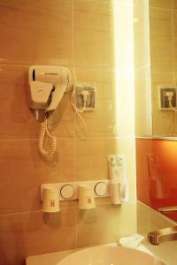 a bathroom with a hair dryer and a phone on the wall at 7Days Premium Zhangjiakou Huailai County Shacheng Branch in Huailai