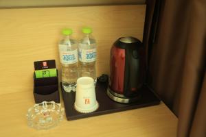 a cupboard with two bottles of water and a blender at 7Days Premium Yantai Penglai New Bus Station Branch in Penglai