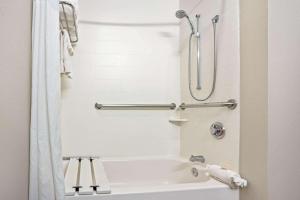 a bathroom with a white tub and a shower at La Quinta by Wyndham Houston North-Spring in Spring