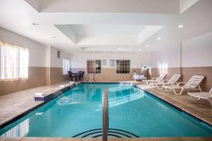 a large swimming pool in a room with chairs at La Quinta by Wyndham Columbus TX in Columbus