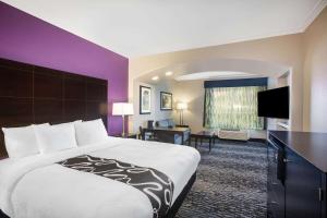 a hotel room with a large bed and a desk at La Quinta by Wyndham Columbus TX in Columbus +32 photos