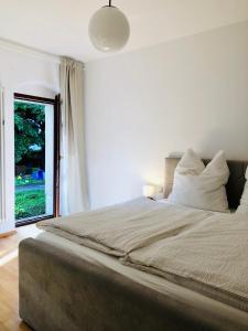 ein Schlafzimmer mit einem großen Bett mit einem großen Fenster in der Unterkunft Ferienwohnungen mit Terrasse in Zwingernähe - Hilger Rentals in Dresden