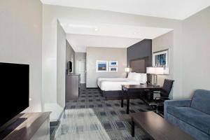 a hotel room with a bed and a living room at La Quinta by Wyndham Victoria - South in Victoria