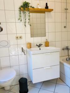 ein Badezimmer mit einem weißen Waschbecken und einer Toilette in der Unterkunft Ferienwohnungen mit Terrasse in Zwingernähe - Hilger Rentals in Dresden