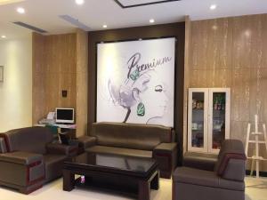 a salon room with a couch and a poster of a woman at 7Days Premium Shenzhen Dalang Commercial Center Branch in Shenzhen
