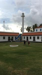 a group of people walking in front of a lighthouse at Casa de Praia Tamandare in Tamandaré