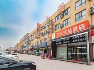 una calle con edificios y coches estacionados en la calle en 7Days Premium Zhengzhou Fangte Green Expo Park Branch, en Zhengzhou