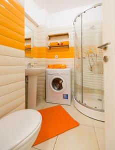 een badkamer met een toilet en een wasmachine bij Bucharestby Apartments in Boekarest