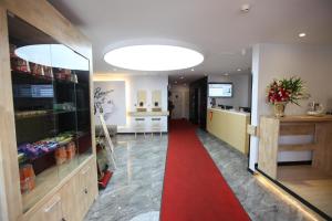 a store with a red carpet in the middle of a room at 7Days Premium Harbin Xuefu Road Branch in Harbin