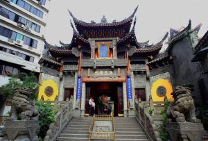 een gebouw met twee standbeelden ervoor bij 7Days Premium Chongqing Jiefangbei Pedestrian Street Branch in Chongqing