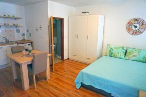 1 dormitorio con cama, mesa y cocina en Apartment Denis en Rovinj