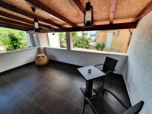 balcón con mesa, sillas y ventanas en Apartment Denis en Rovinj