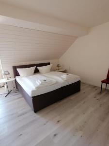 a large bed in a room with a wooden floor at Hotel zur Post in Arnsberg