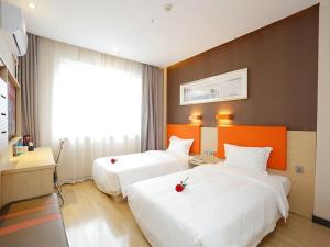 a hotel room with two beds with apples on them at 7Days Premium Tangshan Xiaoshan People's Hospital Branch in Tangshan +20 photos