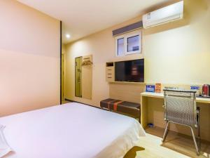 a bedroom with a bed and a desk and a tv at 7Days Premium Beijing Happy Valley Wangsiyingqiao Branch in Beijing