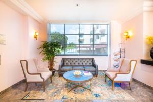 a living room with a couch and two chairs and a table at Days Inn by Wyndham Santa Monica in Los Angeles
