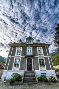 uma casa grande com escadas que levam até à porta em Villa Gracieuse em Luchon