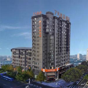 a tall gray building with an orange sign on it at 7Days Premium Xingtai Railway Station Tianyi Street Branch in Xingtai