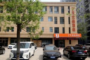un groupe de voitures garées devant un bâtiment dans l'établissement 7Days Premium Shijiazhuang Jianhua South Avenue South Second Ring Branch, à Shijiazhuang