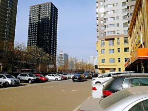 ein Parkplatz voller Autos in einer Stadt in der Unterkunft 7Days Premium Shijiazhuang Jianhua South Avenue South Second Ring Branch in Shijiazhuang