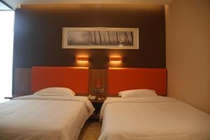 Zimmer mit 2 Betten und einem Bild an der Wand in der Unterkunft 7Days Premium Shijiazhuang Jianhua South Avenue South Second Ring Branch in Shijiazhuang