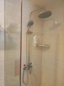 a shower with a shower head in a bathroom at 7Days Premium Yichang Gezhouba Branch in Yichang