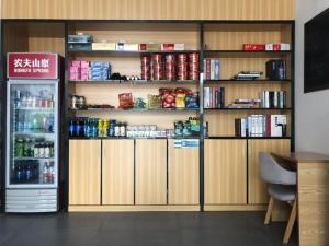a room with a refrigerator and shelves with food at 7Days Premium Yichang Gezhouba Branch in Yichang