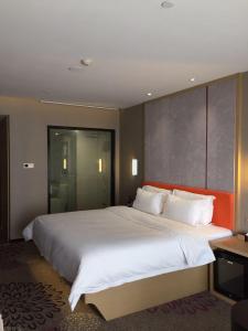 uma grande cama branca num quarto de hotel em 7Days Premium Chengdu Global Center New Exhibition Branch em Chengdu