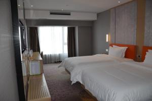 um quarto de hotel com duas camas e uma janela em 7Days Premium Chengdu Global Center New Exhibition Branch em Chengdu