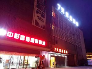 a building with neon signs on the side of it at 7Days Premium Kunming University Town Subway Station Branch in Huacheng