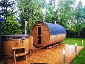 une grande cabine en bois sur une terrasse avec un bain à remous dans l'établissement Villa Watamu, à Trzęsacz