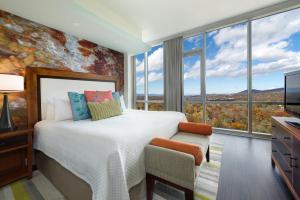 a bedroom with a large bed and large windows at Hotel Indigo Asheville Downtown, an IHG Hotel in Asheville