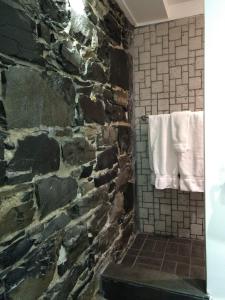 a stone bathroom with a towel hanging on a wall at C3- Hotel Art De Vivre in Quebec City