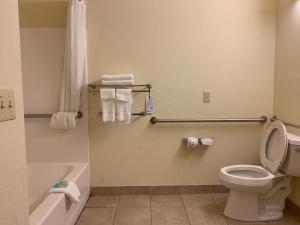 a bathroom with a toilet, sink, and shower stall at Rincon Inn and Suites in Rincon