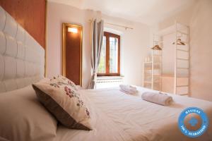 a bedroom with a large white bed with two pillows at Giardino in Centro in Perugia