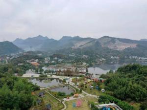 a view of a town with a lake and mountains at 7Days Premium Yichang CBD Business Center Branch in Yichang