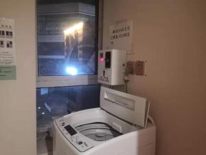 a white toilet in a bathroom with a light at 7Days Premium Yancheng Dafeng Zhongjiao Meilucheng Branch in Yancheng