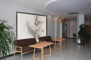 a room with tables and chairs and a large screen at 7Days Premium Dingxi Train Station Branch in Dingxi