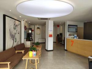 a lobby with a couch and tables in a room at 7Days Premium Dingxi Train Station Branch in Dingxi