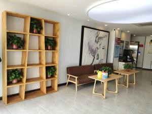 a waiting room with a couch and two tables at 7Days Premium Dingxi Train Station Branch in Dingxi