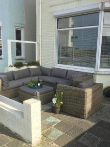 um sofá sentado em frente a uma casa em Appartement Drommel em Zandvoort