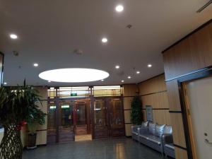 een grote lobby met banken en een groot licht bij 7Days Premium Heihe Nenjiang County Keyun Station Branch in Nenjiang