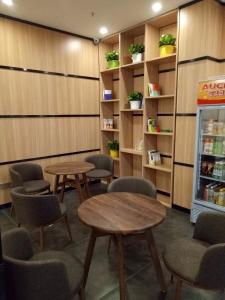 a waiting room with tables and chairs and a refrigerator at 7Days Premium Heihe Nenjiang County Keyun Station Branch in Nenjiang