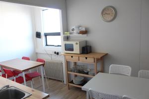 une petite cuisine avec une table et un four micro-ondes dans l'établissement Sunnuberg Guesthouse, à Hofsós